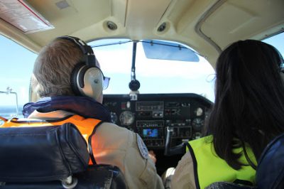 Pilot och deltagare på Bungelägret som sitter i ett flygplan och är ute på en flygning under Flygläger på Bunge.