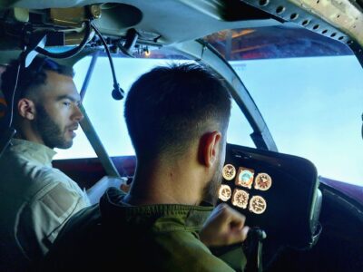 Två killar fyger en helikoptersimulator och diskuterar flygningen. 
